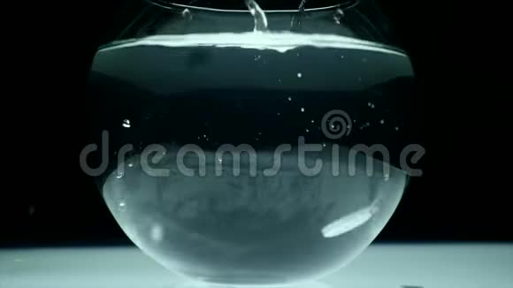 落入一杯水中的平板电脑对抗黑暗的背景视频的预览图