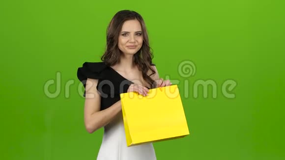 布鲁内特女孩手里拿着一个礼品袋她喜欢绿色屏幕视频的预览图