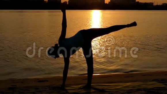 女孩在海滩日落时做瑜伽玫瑰视频的预览图