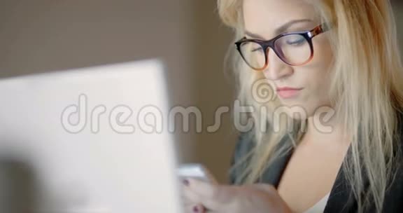 女商人使用智能手机并查看笔记本电脑上的财务数据视频的预览图