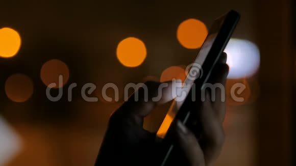 夜间使用垂直黑色智能手机的女性视频的预览图