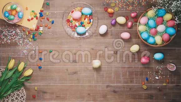 复活节彩蛋旋转在用复活节彩蛋装饰的桌子上顶部视图视频的预览图