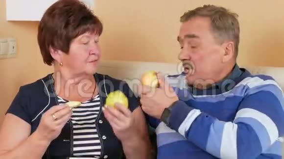 老两口在家里躺在沙发上吃苹果桌子上有一盘不同的水果丈夫和视频的预览图