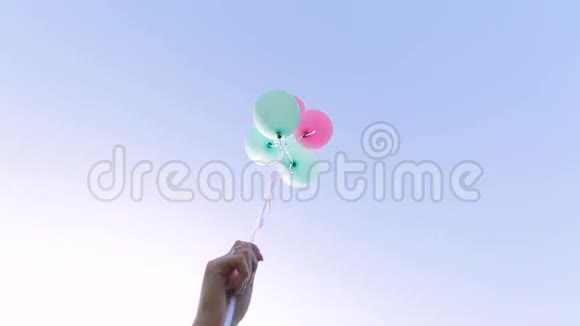 女孩放飞天空背景上的气球视频的预览图