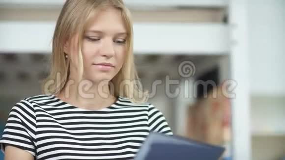 一个穿着条纹毛衣的年轻女孩手里拿着一个蓝色的文件夹视频的预览图