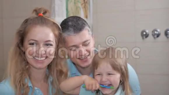 妈妈和爸爸教小女儿清洁牙齿视频的预览图