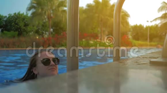漂亮的女孩从游泳池里出来夏日的阳光慢动作视频的预览图