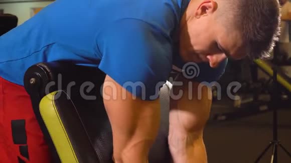 肌肉男健身器在肱二头肌上提升杠铃视频的预览图