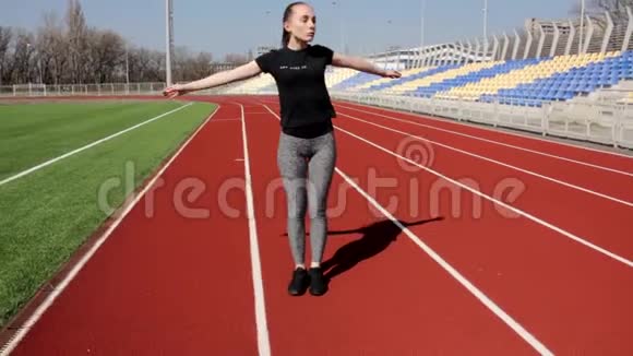有吸引力的年轻积极健康的女孩锻炼做腿部上半身伸展运动在大体育场温暖音调肌肉视频的预览图