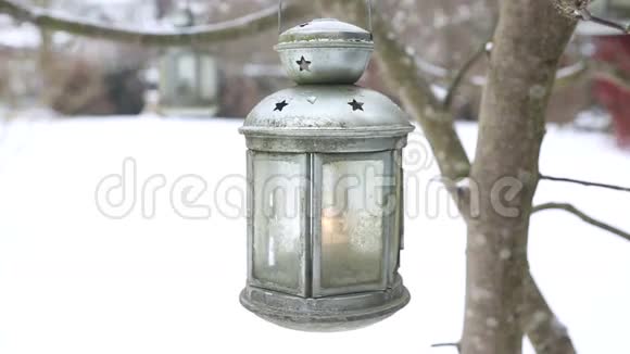 雪中的花园里挂着蜡烛的灯笼视频的预览图