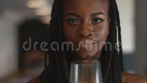 极度接近年轻漂亮的非裔美国女时装模特手里拿着空酒杯视频的预览图