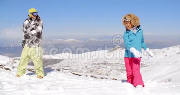 穿着雪衣的情侣在雪地里玩耍视频的预览图