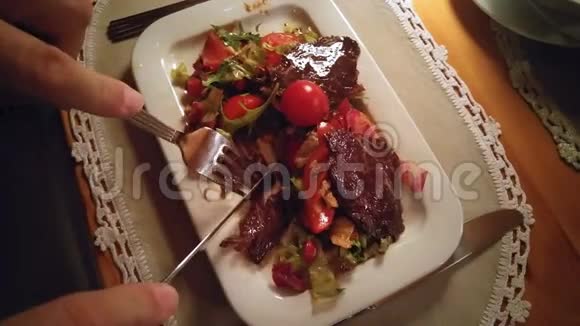 一个人在餐馆吃肉和蔬菜的点心视频的预览图