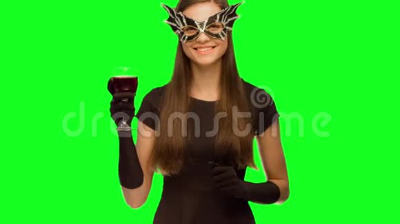 戴着面具和黑色连衣裙的女孩喝酒新年快乐视频的预览图