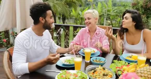 健康素食健康饮食朋友交流坐在餐桌上的热带露台视频的预览图