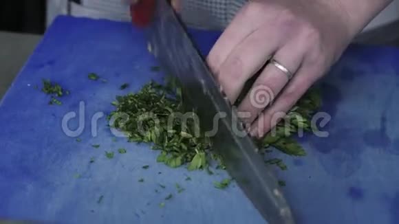 厨师双手剁碎的绿色食品在一个商业厨房的板上装饰视频的预览图