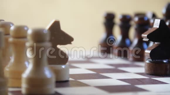 国际象棋骑士与国际象棋骑士在黄金背景上的其他人物盘着旋转镜头对称视频的预览图