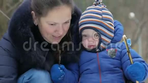 可爱的妈妈和宝宝在冬天的森林里雕刻小雪人圣诞假期的家庭乐趣视频的预览图