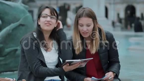 两个女孩在伦敦市中心读旅游指南视频的预览图