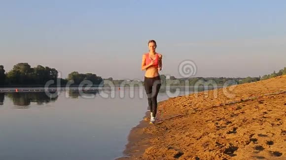 身材苗条的女人在日出时在河边做体操视频的预览图