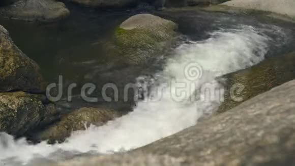 在热带森林中流淌的山河大石头上的瀑布流出来的河水视频的预览图