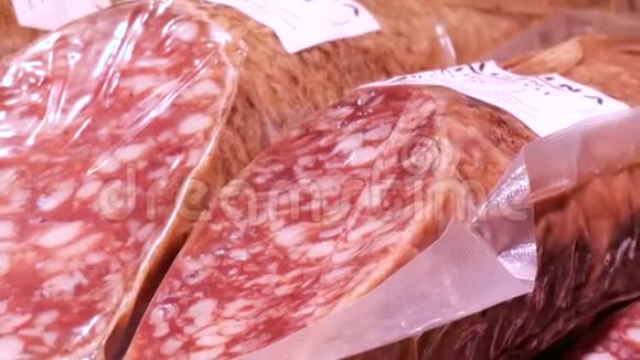 美味的新鲜腊肠挂在肉贩市场柜台上视频的预览图