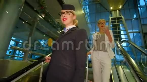 带着眼镜的空姐走下扶梯微笑着视频的预览图