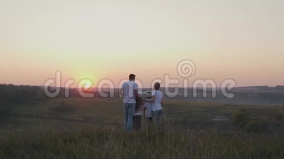 日落时分在田野里的幸福家庭视频的预览图