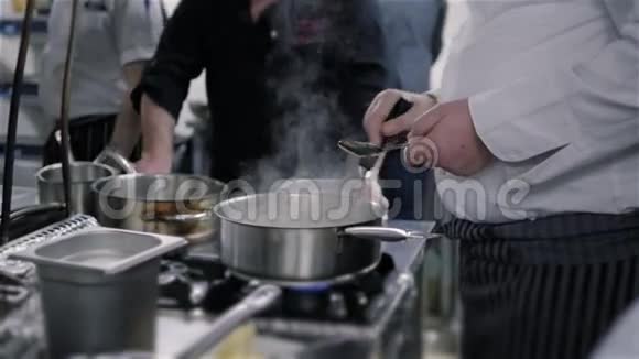 厨师大师班在商业厨房里的锅里煮汤视频的预览图