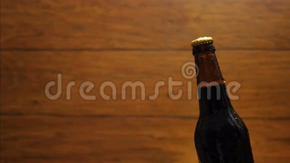 冷瓶啤酒放在木头背景上从瓶子里流下来视频的预览图