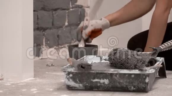 一个女人用油漆刷在灰色的砖墙上画特写视频的预览图