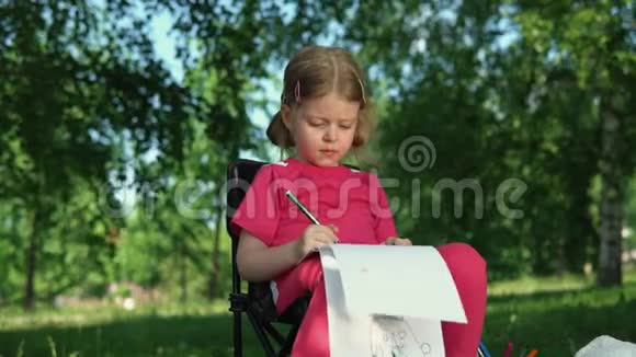 夏天在公园户外画铅笔的小女孩的肖像视频的预览图