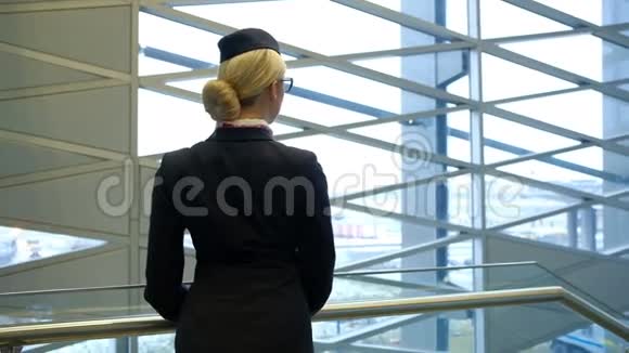 戴着眼镜的空姐望着窗外的城市视频的预览图