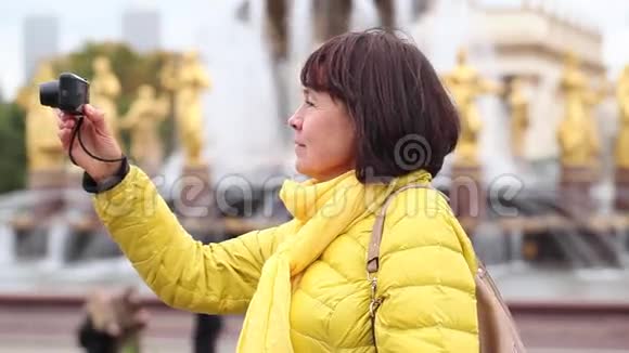 穿黄色夹克的成年旅游妇女视频的预览图