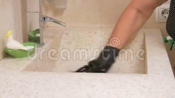 高级女人打扫酒店房间浴室的水槽她用手套和清洁剂在海绵的手里视频的预览图