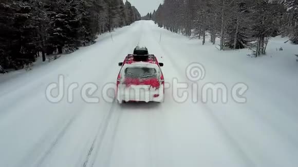 鸟瞰道路上唯一的红色汽车在美丽的冬季景观拉普兰后降雪视频的预览图