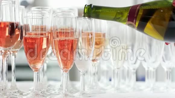 杯子里倒着香槟女人手里拿着瓶子杯子里倒着玫瑰香槟视频的预览图