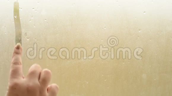 女性手指在潮湿的窗户上画出心形视频的预览图