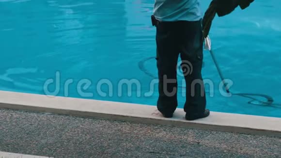 以工作形式清洁蓝色游泳池底部的人视频的预览图