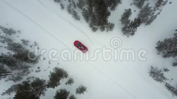 在美丽的拉普兰冬季景观的道路上唯一的红色汽车在降雪期间的空中景观视频的预览图
