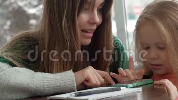 小美女和妈妈在咖啡馆打电话视频的预览图