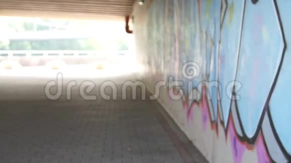 女孩带着电吉他走在涂鸦墙附近视频的预览图