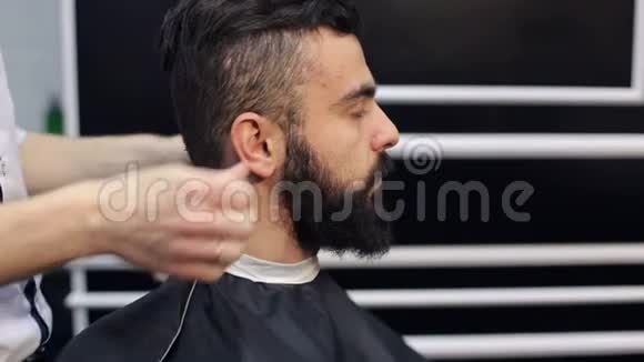 一个留胡子的年轻男子在理发师特写视频的预览图
