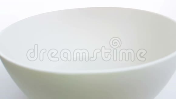 谷物玉米片落在碗里在白色背景下缓慢运动饮食健康食品的概念视频的预览图