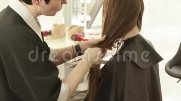 理发师在美发沙龙女性理发时梳湿头发关闭理发师在视频的预览图
