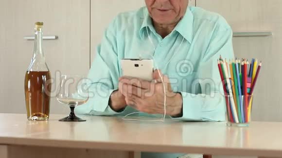 有智能手机的男人坐在桌子旁视频的预览图