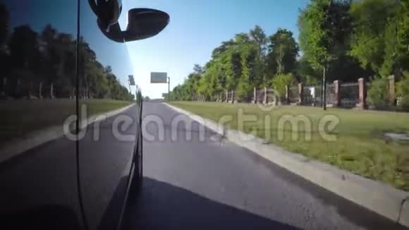 在阳光明媚的夏日汽车沿着城市街道沿着公园行驶视频的预览图