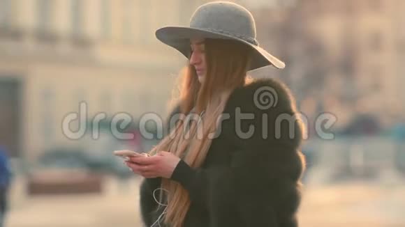站在市中心时阳光明媚的女人用手机视频的预览图