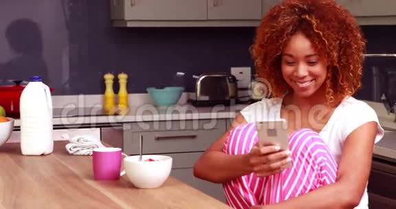 吃早餐的漂亮女人用智能手机视频的预览图
