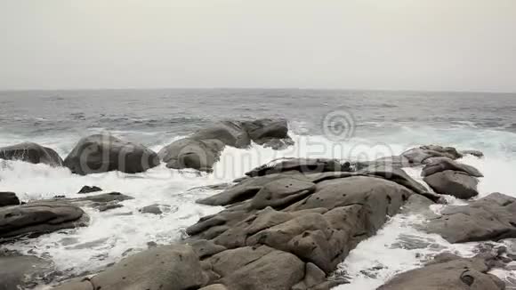 暴风雨中海浪撞击巨石浪花飞溅四面八方视频的预览图
